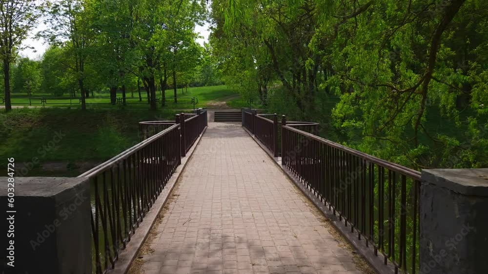 Slow walk along bridge over canal in park Slow walk along bridge over canal in park