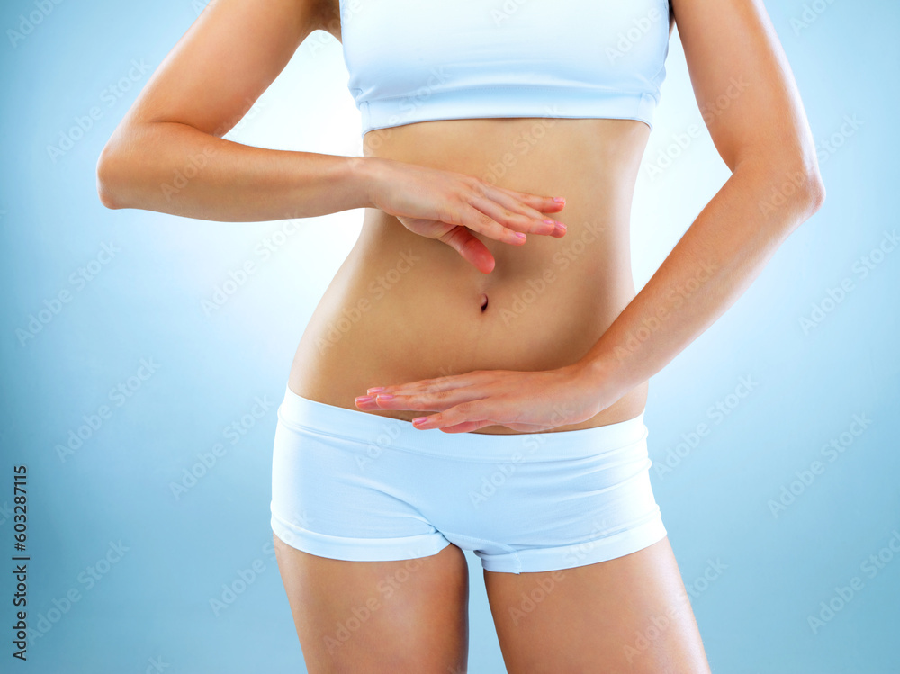 Woman, stomach and body with blue background with hands for diet and exercise for health. Model, fitness and women in studio for digestion diet and workout with weight loss for healthy living. Woman, stomach and body with blue background with hands for diet and exercise for health. Model, fitness and women in studio for digestion diet and workout with weight loss for healthy living.