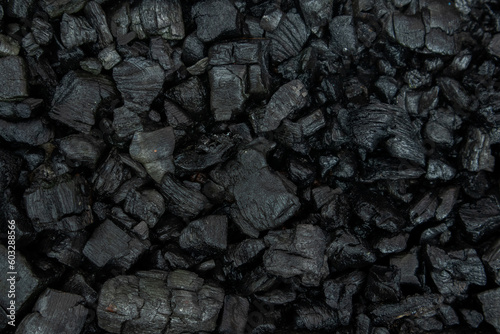 Dark coal texture, the remnants of wood burning into charcoal that can be used for barbecue. selective focus and soft focus