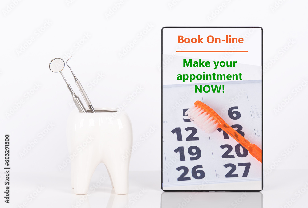 Dentist appointment date or any other message on tablet with ceramic tooth with dental tools.