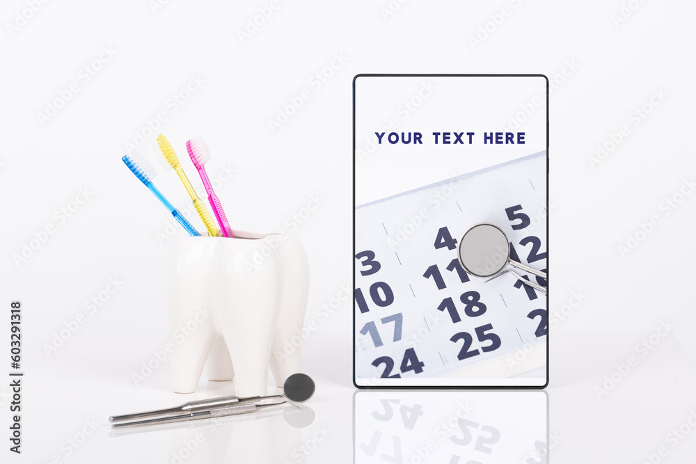 Dentist appointment date or any other dental message on tablet, ceramic tooth with three bright colors toothbrushes and dental tools mock up. White background.