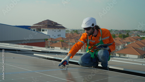 Wallpaper Mural Male engineer maintaining solar cell panels on building rooftop. Technician working outdoor on ecological solar farm construction. Production of renewable energy concept. Torontodigital.ca