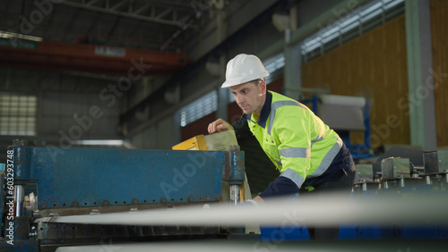 Male engineer meticulously inspected the complex workings of the machine, intent on solving the issue himself.