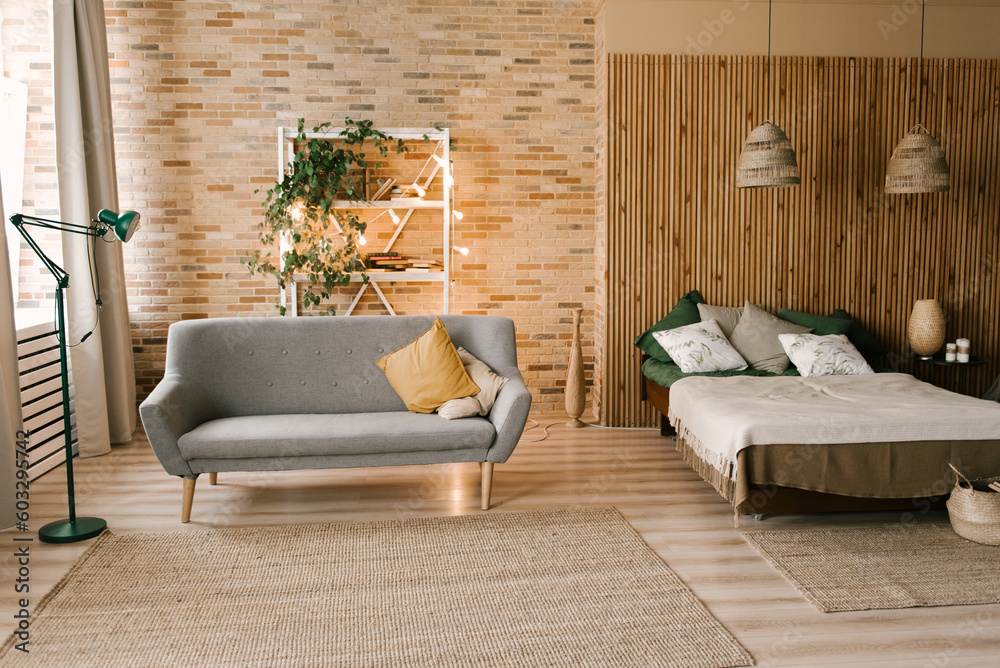 Modern boho bedroom interior with wooden slats, wicker lamps, emerald textiles