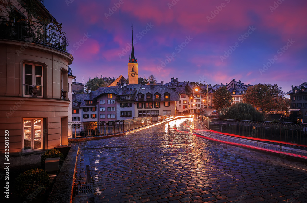 Incredible vivid cityscape. Scenic view Historical Old Town of Bern city with colorful sky, view on bridge over Aare river and church tower during dramatic sunset. Bern. Switzerland. Europe