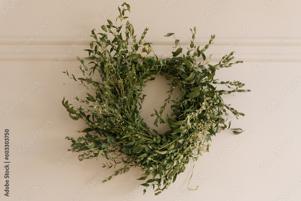 A round spring green wreath adorns the wall A round spring green wreath adorns the wall
