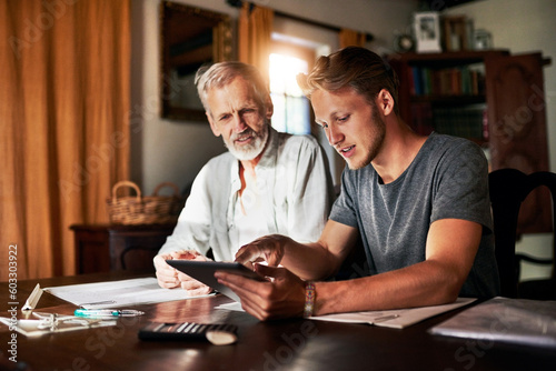 Tablet, investment or retirement with a father and son in their home for savings, budget or finance planning. Accounting, money or insurance with a man helping his senior pensioner parent in the home photo