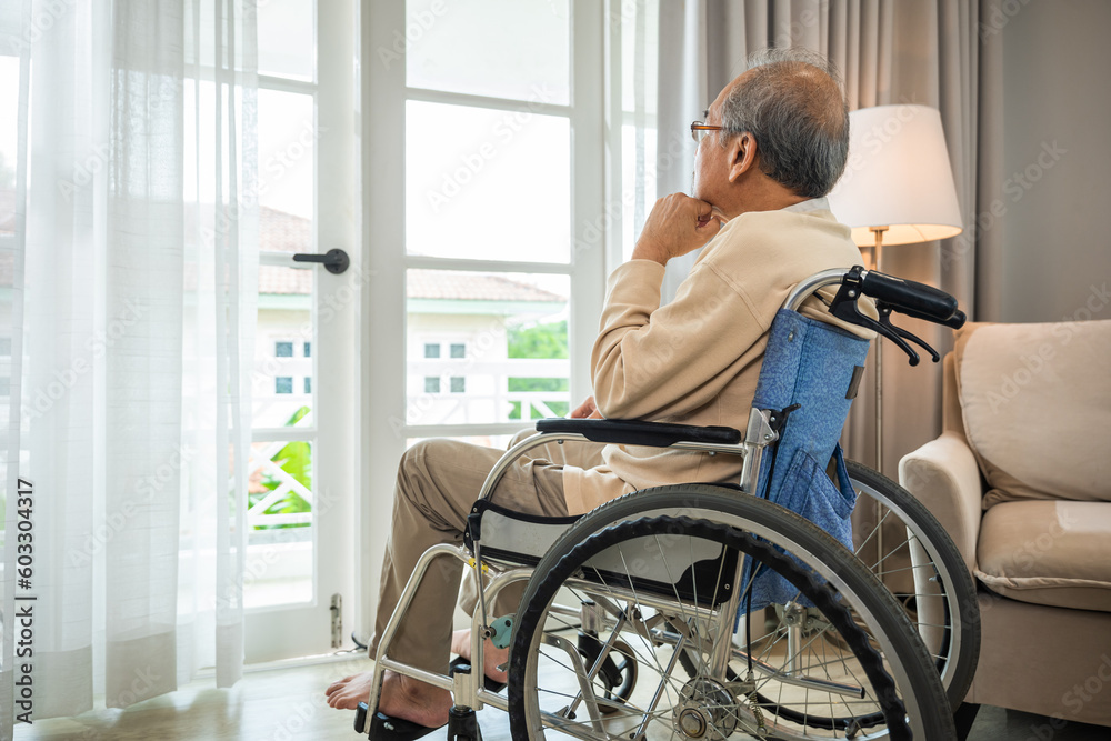 Asian senior man disabled sitting alone in wheelchair looking through window at hospital, lonely elder thoughtful sad old man look outside windows in bedroom at retirement home, feel depressed lonely - obrazy, fototapety, plakaty 