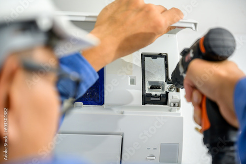 Air conditioner technician repairs and installs air conditioners Power drill is being used to repair air conditioners in homes and buildings.