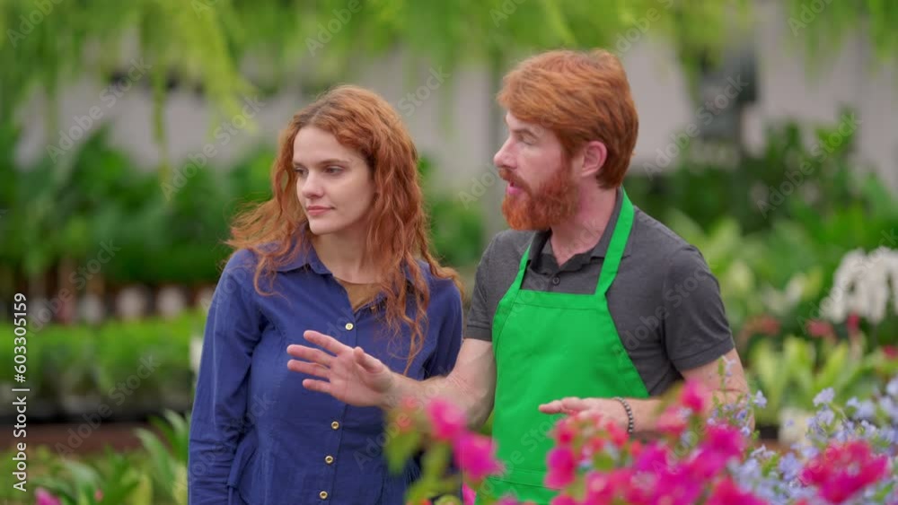 A male staff of Flower Shop speaking with female customer inside Horticulture gardening retail store A male staff of Flower Shop speaking with female customer inside Horticulture gardening retail store
