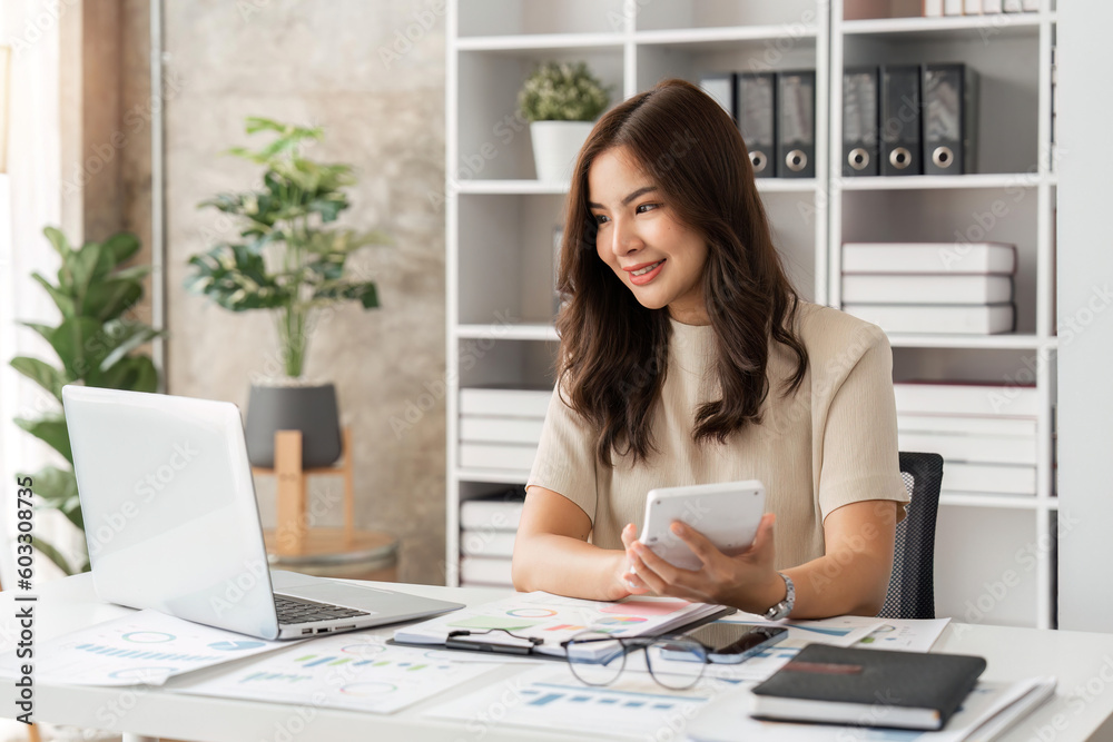 Businesswoman sits at work with laptop and computer and analyzes corporate and tax activities at office