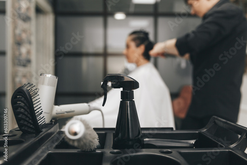 Professional barber set on a blurred background with a hairdresser doing a haircut to a client