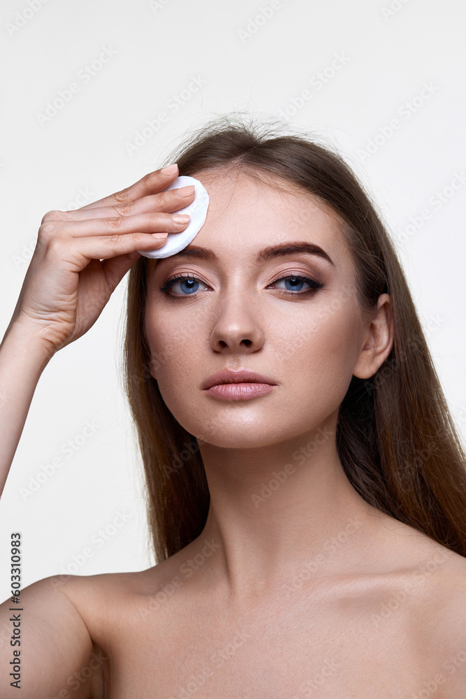 woman holding white cotton pad for removing makeup woman holding white cotton pad for removing makeup