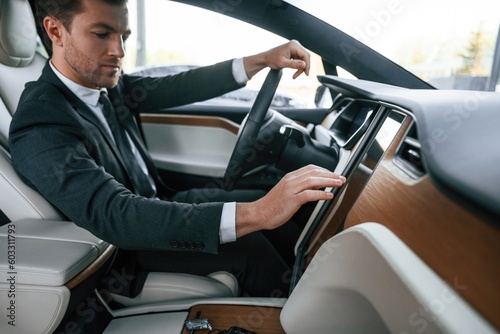 Businessman in suit is driving his electric car © standret