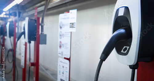 Electric car charging station for charge EV battery. Plug for electric vehicle. EV charger. Charging point at car parking lot of the mall. Clean and sustainable energy. Commercial EV charging point.