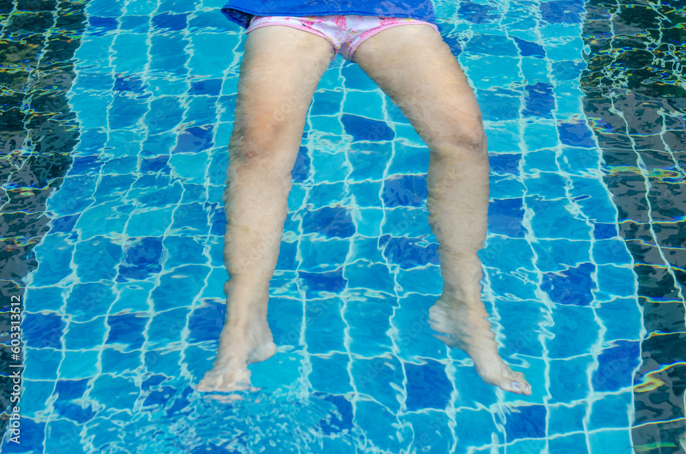Woman leg cramps in swimming pool