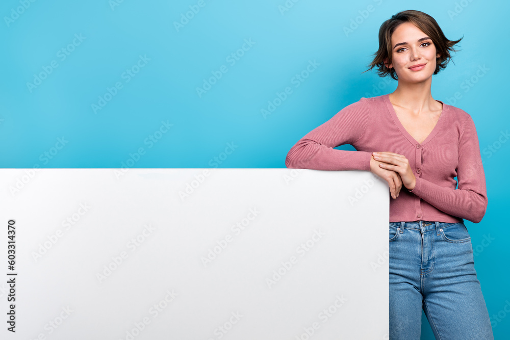 Photo of optimistic woman with bob hairstyle dressed pink cardigan lean on white placard empty space isolated on teal color background Photo of optimistic woman with bob hairstyle dressed pink cardigan lean on white placard empty space isolated on teal color background