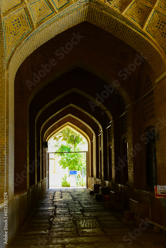 "Vakil" mosque praying hall with spiral pillars of stones and roof tiling illuminated with sunlight located in Shiraz; Iran