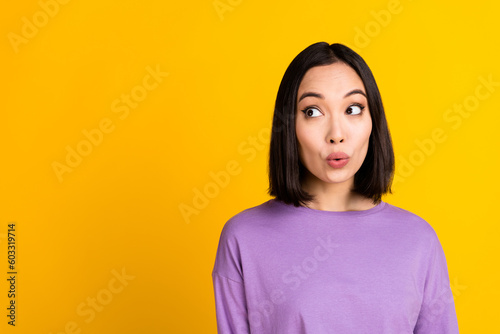 Portrait of japanese young woman black hair look empty space pouty lips surprise low prices hypermarket isolated on yellow color background