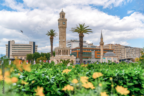 Izmir, Turkey - April 28 2023: Konak Square with old clock tower and mosque just above the flowers in the spring photo