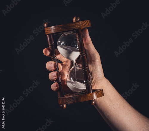 Time is running - hand with hourglass