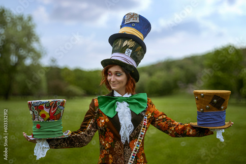 Beautiful woman as mad hatter with hats in nature
