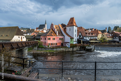 Romantic historical building with wooden bridge with weir on river Vltava, Cesky Krumlov.