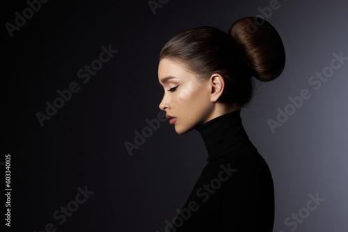 Fashion art studio portrait of beautiful elegant woman in black turtleneck. Hair high beam, perfect profile face. Elegant beauty style. Earrings in the ears photo