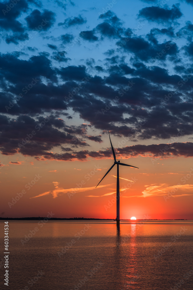 Wind turbine in the sea in the warm sunset light