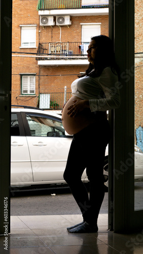 silhouette of pregnant young woman in street setting