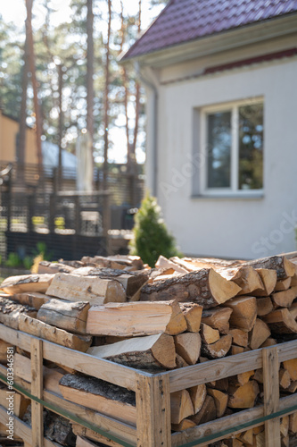 Pallet with firewood on private backyard with house on background