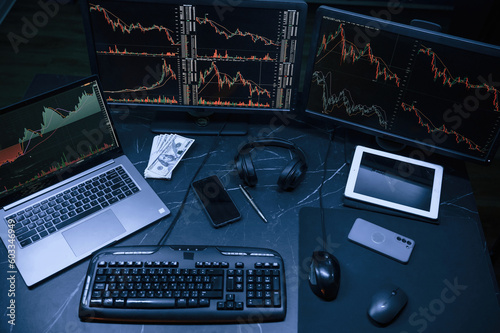 Financial Analyst Working on a Computer with Multi-Monitor Workstation with Real-Time Stocks, Commodities and Exchange Market Charts