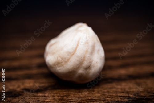 close-up and front shot of hazelnut on wooden table  detailed shot of hazelnut on table on black background