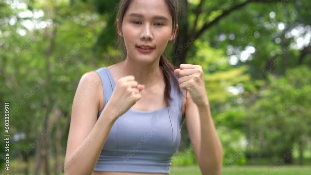 Fitness Asian Girl in tight sportswear doing exercises and punching boxing footwork cardio exercise in park. Female student boxer motivation. Fitness Asian Girl in tight sportswear doing exercises and punching boxing footwork cardio exercise in park. Female student boxer motivation.