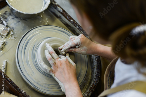 close up view of professional potter working on pottery wheel at workshop. High quality photo