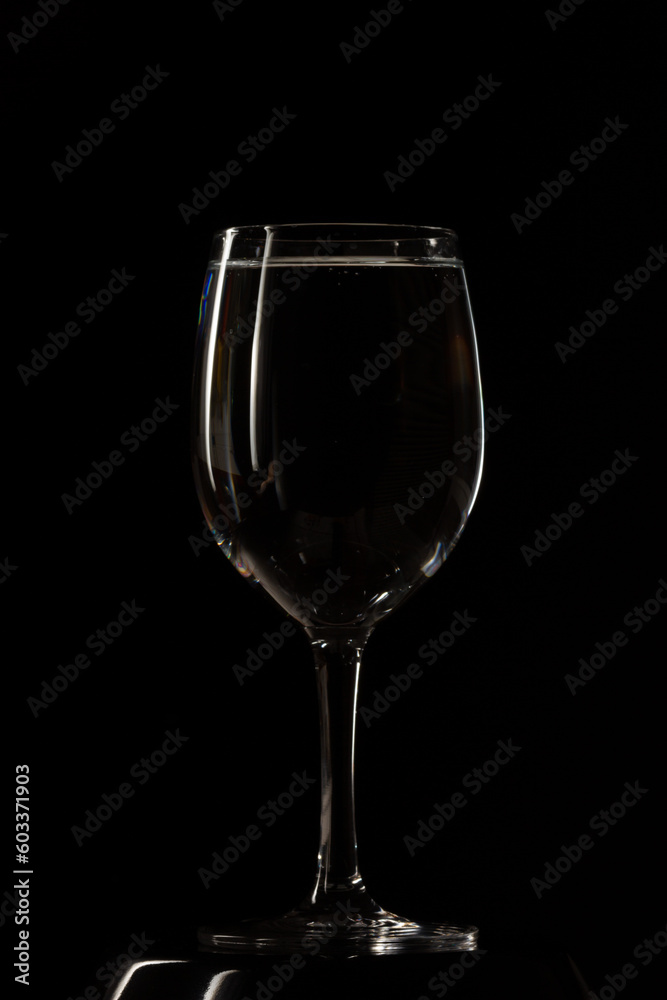 Glass with water on black background