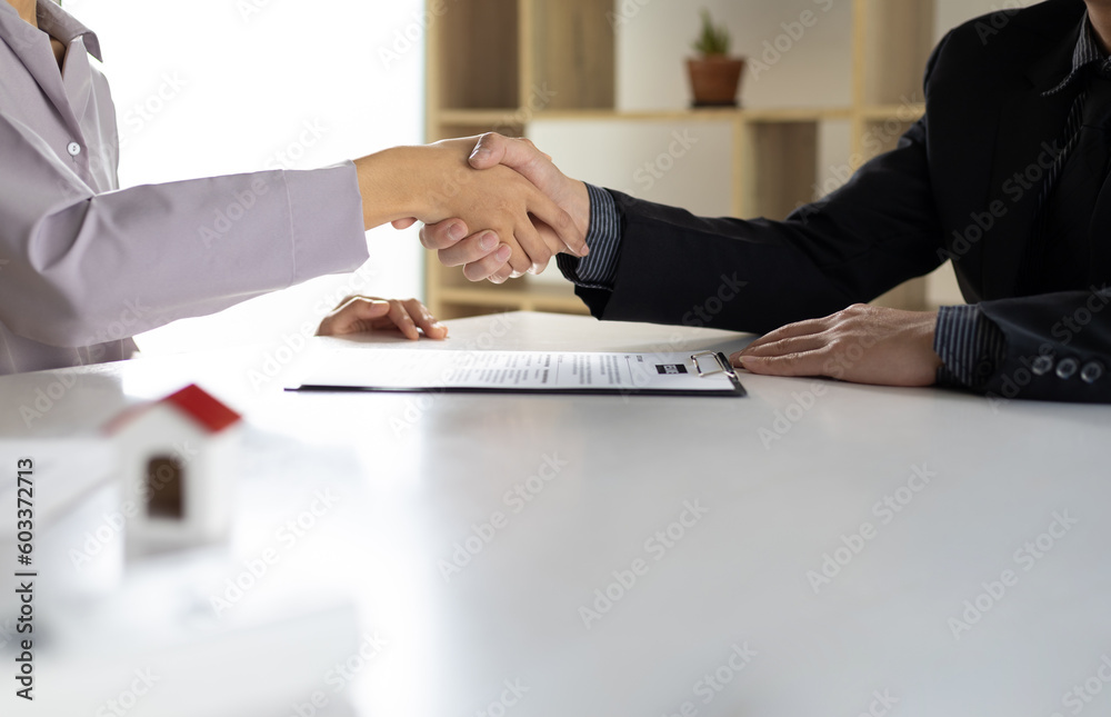 Business, career and placement concept - image of employer sitting in office and shaking hand of young asian woman after successful negotiations or interview. - obrazy, fototapety, plakaty 