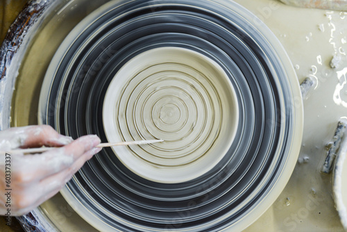 close up view of professional potter working on pottery wheel at workshop. High quality photo