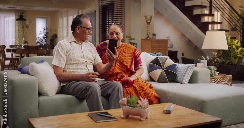 Elderly Couple Using Smartphone for Video Call at Home: Connecting with Loved Ones, Sharing Life's Moments, and Creating Lasting Memories. Embracing Technology to Stay Close. Medium Shot. Elderly Couple Using Smartphone for Video Call at Home: Connecting with Loved Ones, Sharing Life's Moments, and Creating Lasting Memories. Embracing Technology to Stay Close. Medium Shot.