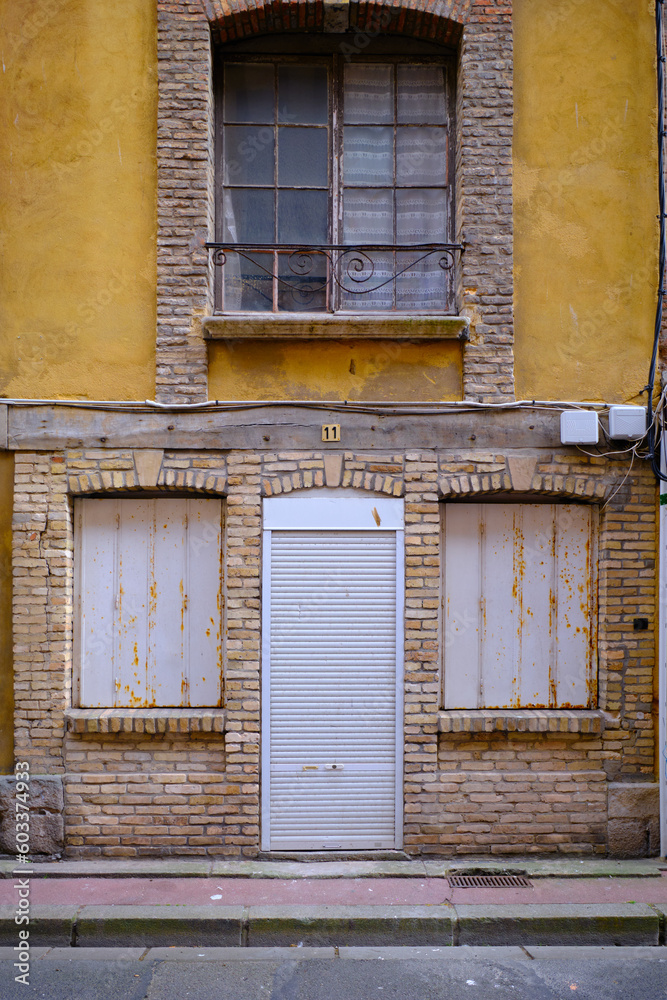 Dieppe, Normandy, France - September 23 2022:An old brick faced buiklding with closed shutters on ground floor door and windows. No people.