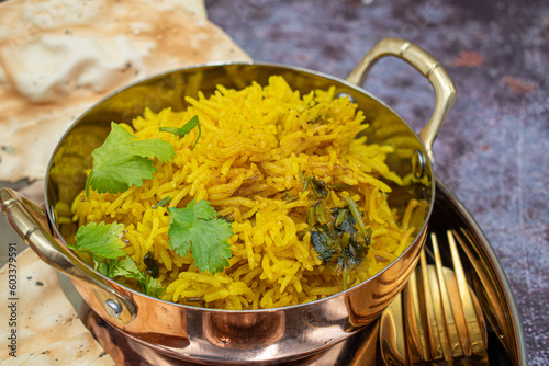 Indian yellow rice pilaf, vegan, vegetarian, served in a traditional copper bowl photo