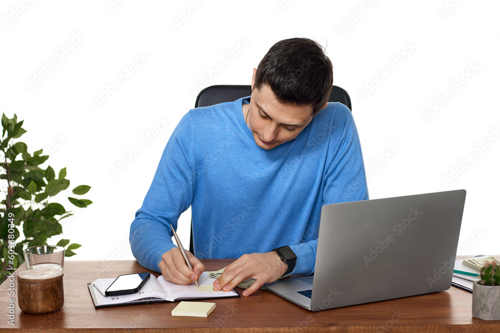 businessman writing while working on laptop at desk. businessman writing while working on laptop at desk.