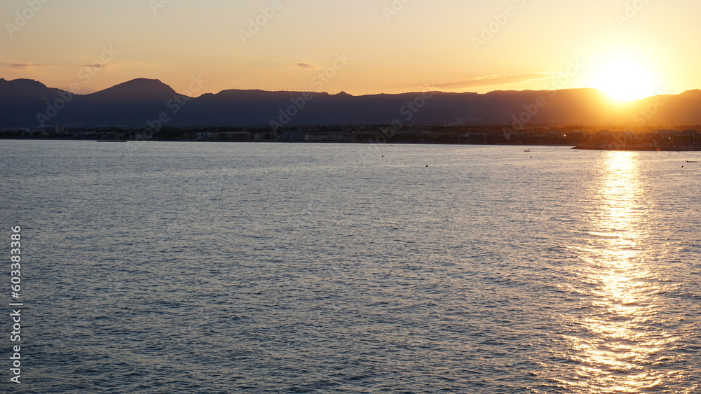 sunset over the water between mountains