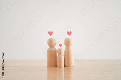 Happy family with one child and heart emotion on wooden background. Wood doll character. Togetherness relationship and lifestyle concept.