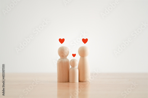 Happy family with one child and heart emotion on wooden background. Wood doll character. Togetherness relationship and lifestyle concept.