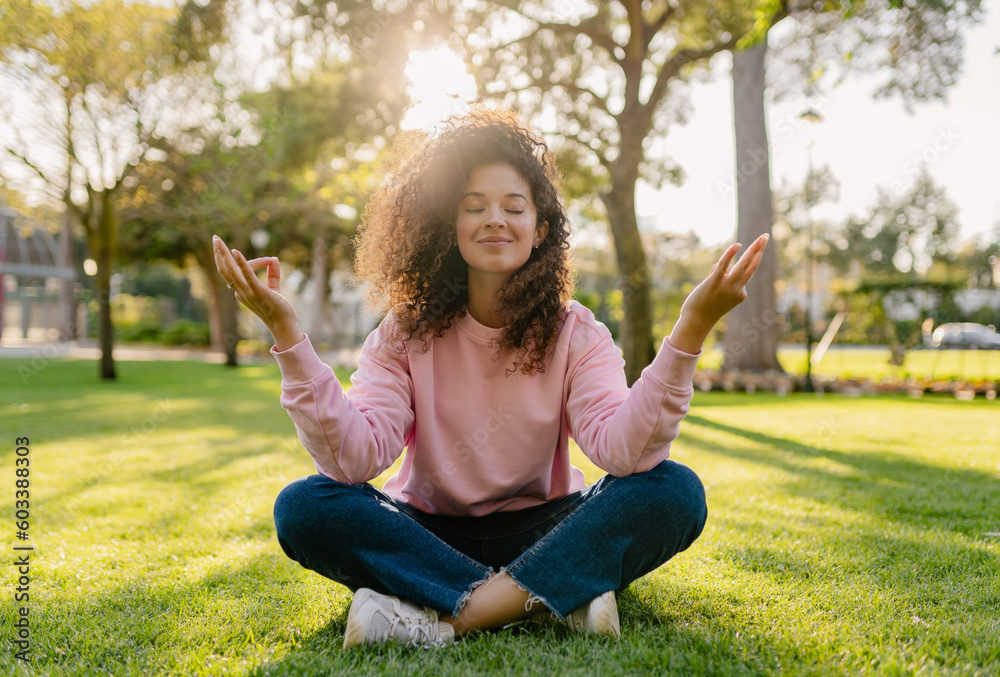 pretty young curly woman making digital detox in park meditating pretty young curly woman making digital detox in park meditating