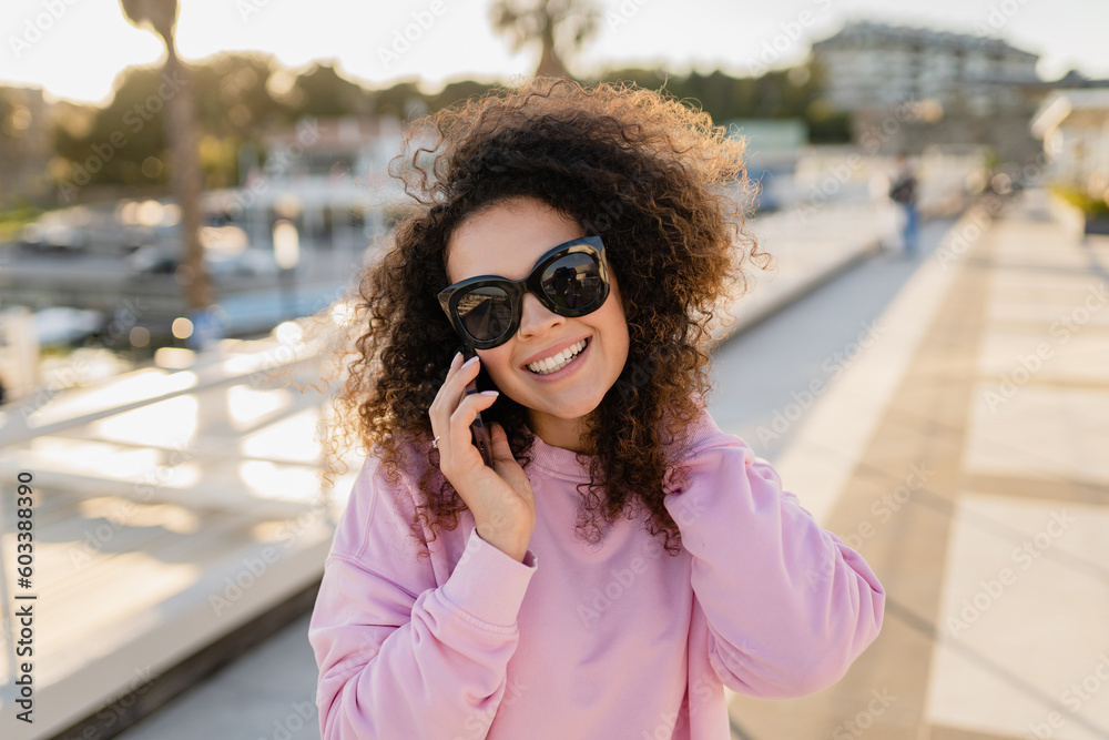 young pretty curly woman in sunglasses on summer vacation with phone young pretty curly woman in sunglasses on summer vacation with phone