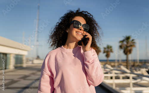 young pretty curly woman in sunglasses on summer vacation with phone © mary_markevich