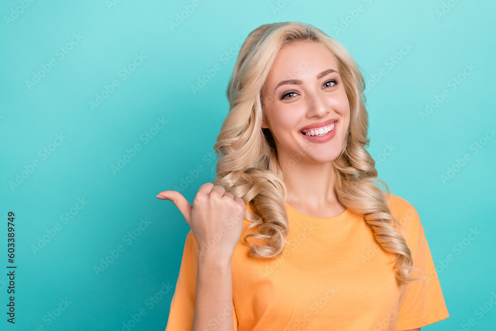 Photo of nice adorable girl with curly hairstyle dressed yellow t-shirt indicating at offer empty space isolated on teal color background Photo of nice adorable girl with curly hairstyle dressed yellow t-shirt indicating at offer empty space isolated on teal color background