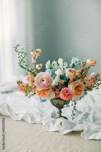 Still life of Flowers bouquet in vintage vase on white linen French tablecloth